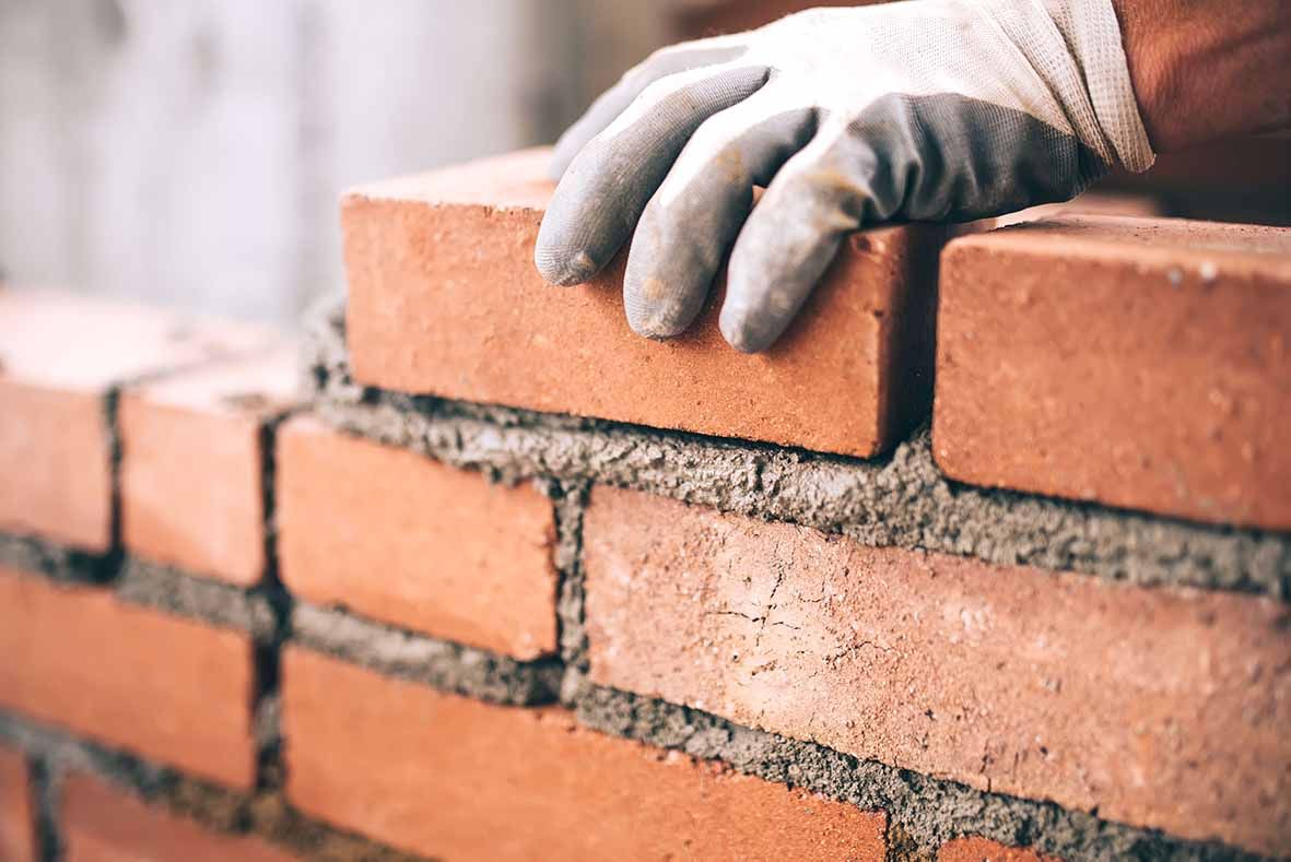 Bricklayer laying a new brick wall